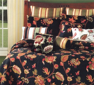 A bold and dramatic traditional Jacobean floral print quilt in shades of red and green on a black background. This luxurious quilt is over-sized to fit today's mattresses.